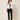 White Ag Bahar Coat on model - front view, white cropped satin jacket worn open over a black camisole, wide shawl collar and draped lapels with soft pointed front panels, sheer floral lace sleeves with solid white cuff bands
