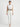 Gray Tina top - front studio view on Ziba with white trousers