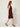 Burgundy textured-stripe sleeveless shift dress, side view walking on model