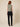 Sage green sleeveless cowl-neck top on model, back view