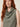 Sage green sleeveless cowl-neck top on model, cowl neckline detail