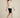 Cream sleeveless cowl-neck top on model, walking side view