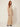 255403 ROSE PLEATED DRESS BEIGE - three-quarter view on model