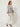 RM1832 gray and gold jacquard cropped jacket on model, three-quarter view, worn open over a cream top and trousers