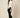 White Ag Bahar Coat on model - three-quarter view showing the open draped front over a black camisole and one sheer floral lace sleeve in profile