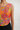 Orange floral cropped top on model, studio