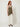 Olive shimmer knit top with floral appliques - three-quarter view on model