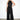 Endo Black Overall — front view on model showing the disc appliqué bodice, halter collar and sash belt