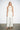 Endo Milk Overall — front view on model showing the lace bodice, halter collar and sash belt